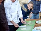 Ein Koch leitet eine Gruppe von Menschen beim Schneiden von Zutaten auf einem Schlosscampus-Workshop an.